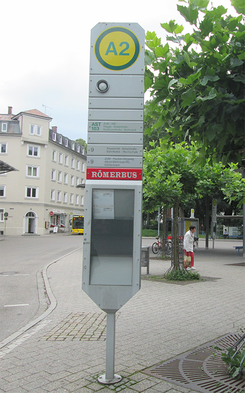 Rote Schilder an Bushaltestellen weisen den Weg zum Römerfest